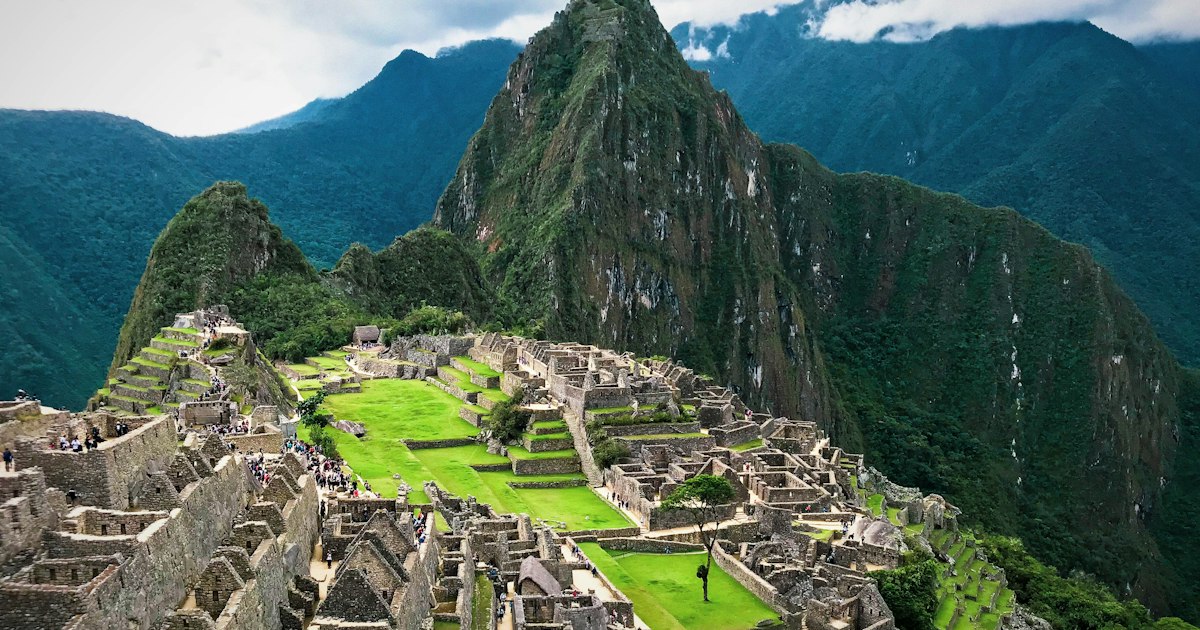 Inca stone ruins and green Andes mountains around Machu Picchu at golden hour